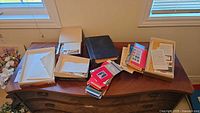 Overview of dresser with boxes, stacks of envelopes, black album