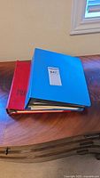 Blue and red stamp albums stacked on table