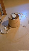 Lamp shade and cord coiled on floor