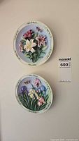 Two Lena Liu relief floral wall plates mounted on wall