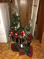 Full lot view showing two artificial trees, four caroler figurines and tree skirt