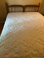 Overall view of headboard, mattress, and part of box spring