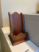 Front view of wooden letter holder showing curved contours and finish