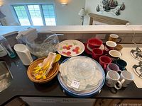 All items on countertop including punch bowl, plates, trays, bowls, mugs, corn holders