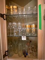 Cabinet view showing multiple shelves of mixed glassware