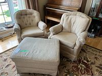 Two upholstered armchairs and matching ottoman in living room
