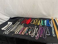 Full lot overview on black backdrop showing all necklaces