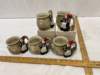 Five matching witch-handle mugs on display