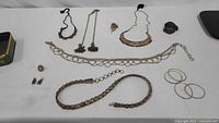 Full layout of all silver-tone jewellery pieces on table