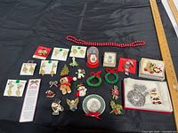 All items laid out on black cloth showing jewelry pieces, necklace, snow globe and packaging