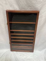 Closed cabinet front view showing glass door and brown frame