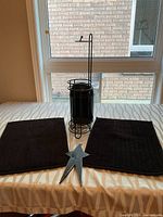 All items on table: two bath mats, toilet paper holder, metal star