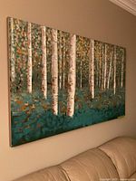 Full view of birch trees canvas painting mounted on wall above sofa