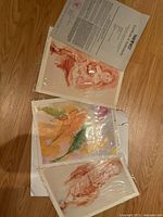 Three Emile Bellet prints in plastic sleeves with COA visible