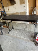 Table standing upright showing top surface and legs