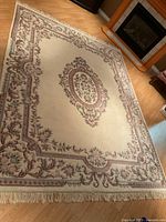 Full view of floral wool rug with fringe