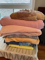 Stack of all six blankets and throws on table