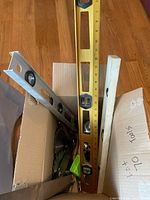 Top view of box with spirit levels, saw blade, tape measure