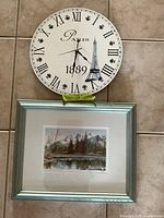 Clock and framed print together for scale and contents