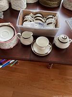 Overview of cups, saucers, creamer and sugar bowl in tote