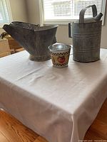 Watering can, scuttle and decorative pail on table