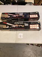 Both boxed 1-ton cable hoist pullers on table