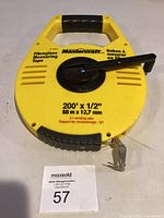 Front view of Mastercraft yellow measuring tape reel