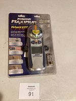 Front view of sealed package showing Mastercraft Maximum Hawkeye laser tool and included battery