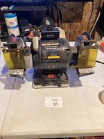 Front view showing full grinder with label, wheels, base and switch