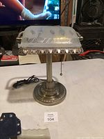 Front view of metal banker lamp with frosted glass shade and base