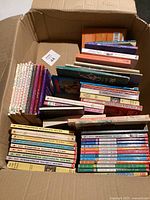Open box showing multiple stacks of children’s paperbacks
