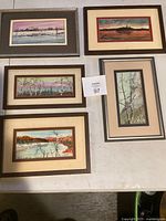 All five framed watercolor paintings laid out