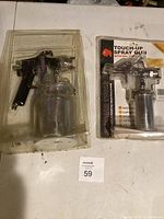Two spray guns in packaging on tabletop