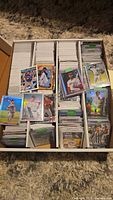 Full long box filled with thousands of trading cards sorted in rows with some sleeved and top-loaded