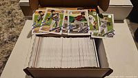 open cardboard card box filled with 2021 Topps baseball cards, five sample cards displayed on flap