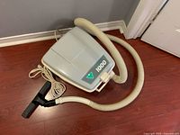 Canister vacuum with hose and nozzle on floor