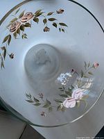 Interior view of glass bowl showing hand-painted rose and leaf design