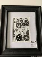 Black frame with white mat showing 5x7 opening