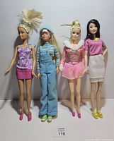 Front view of all four Barbie dolls standing side by side