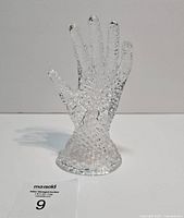 Front view of clear crystal glass hand figurine standing upright