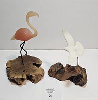 Front view of flamingo and dove sculptures on bases
