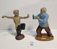 Front view of both mudman figurines showing poses and colours