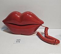 Front view of red lips telephone with coiled cord