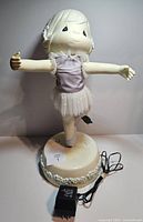 Front view of Precious Moments animated ballerina figure on base with adapter visible