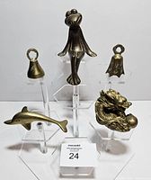 Full view of five brass items displayed upright