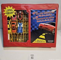 Front of red carry case with window showing cars and printed cardboard insert