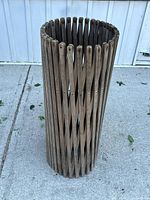 Enclosure folded into cylindrical form, showing vertical wood slats