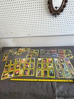 Overview of all trading cards spread out on table with measuring tape