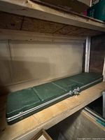 Full view of closed green Safari rifle case on shelf