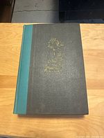 Front cover black cloth with gilt illustration and teal spine